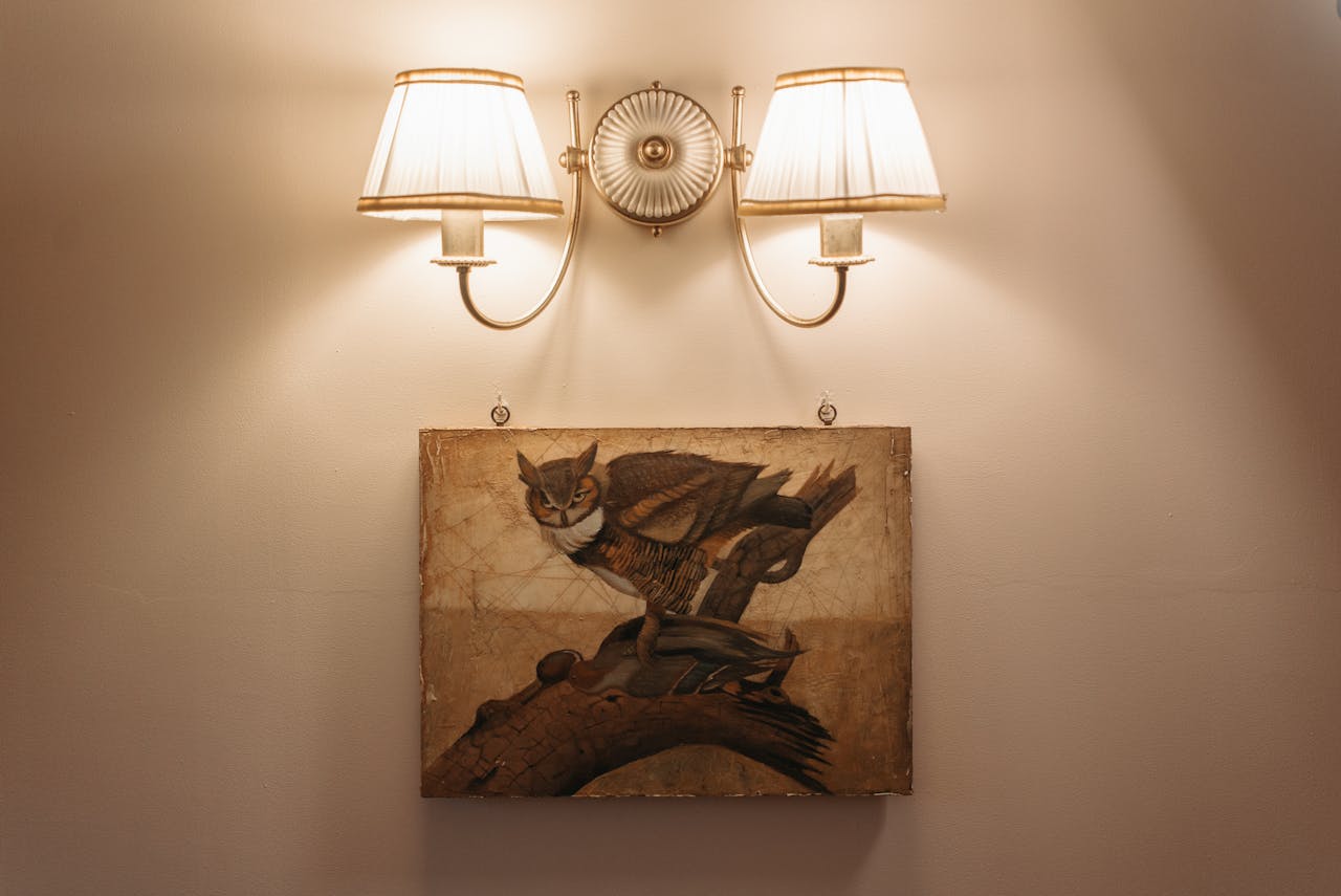 services-02 Vintage painting with dual sconces on a neutral wall for elegant decor inspiration.